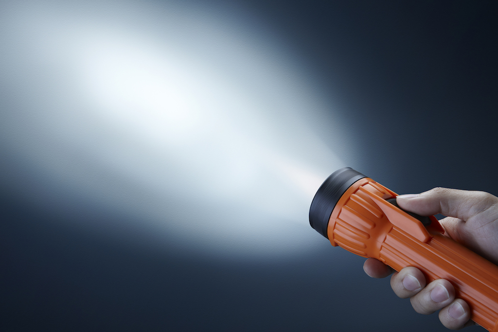Flashlight beaming in darkness during blackout. | Emergency Electrical Service