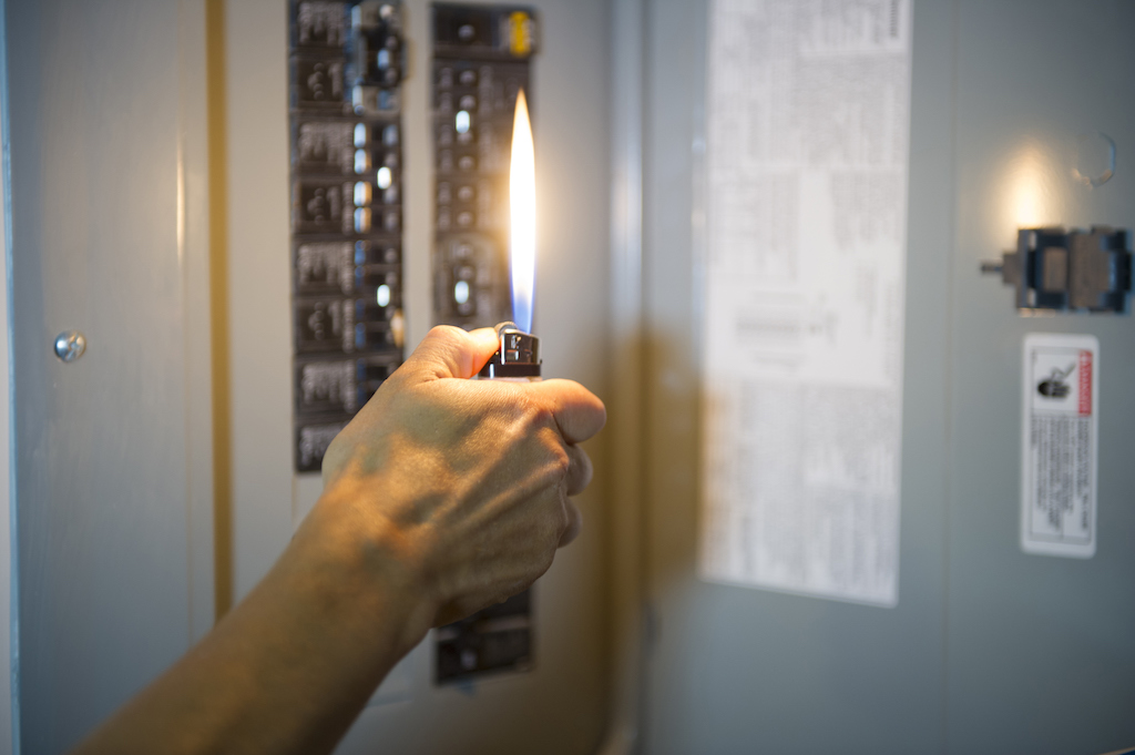 Large lighter illuminating the homes fuse box. | Main Electrical Panel