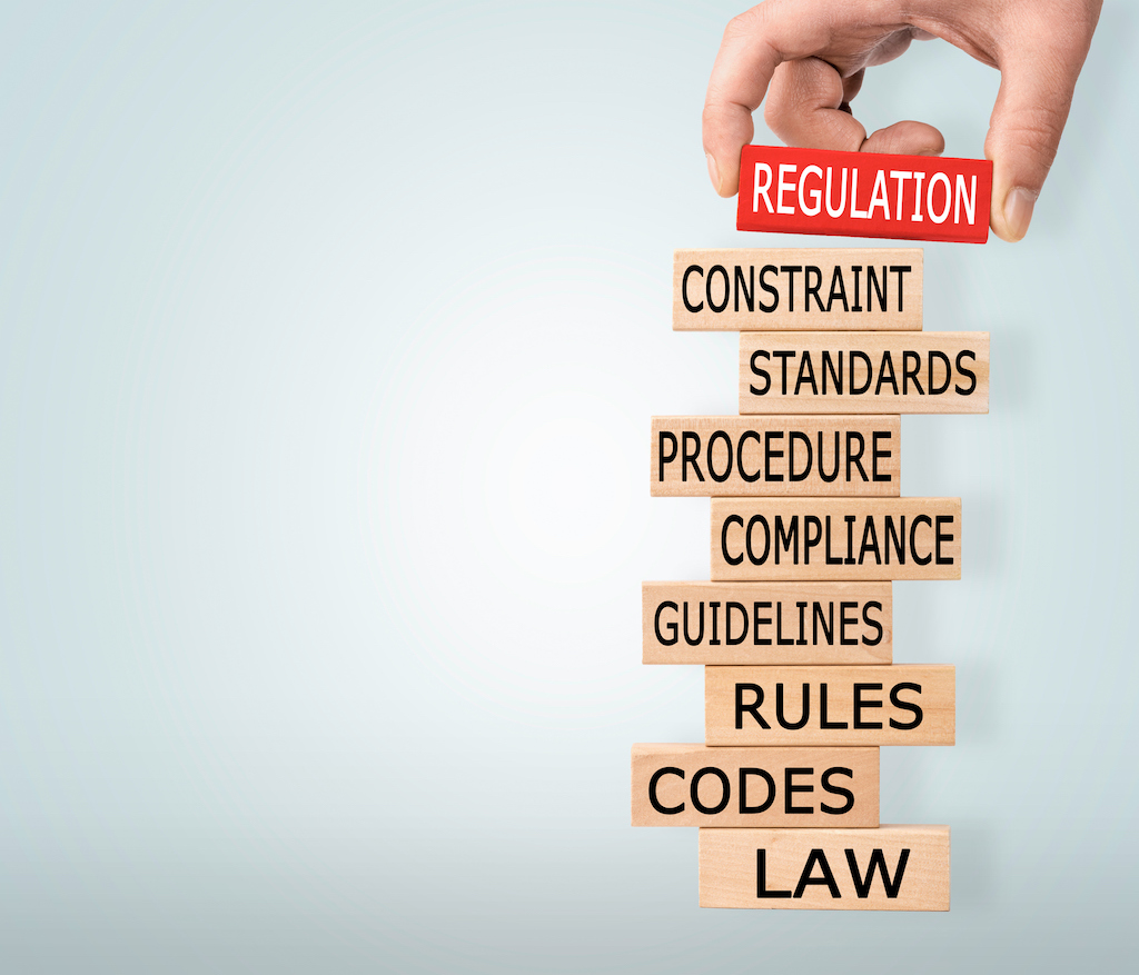 Jenga blocks with words like 'law, compliance, standard, regulation' | Code compliance 