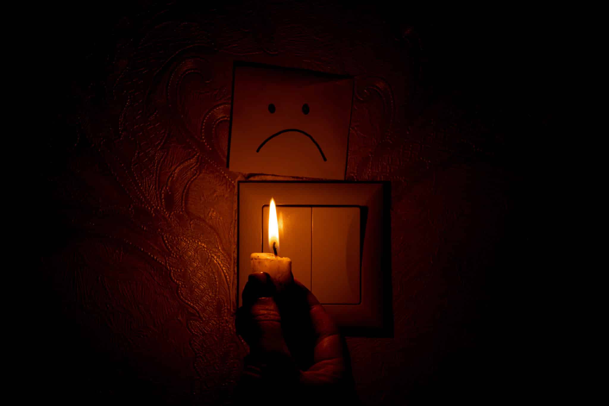 Candlelight during load shedding in a dark home.